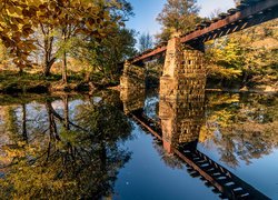 Odbicie mostu i jesiennych drzew w rzece