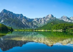 Odbicie pasma gór z drzewami w jeziorze