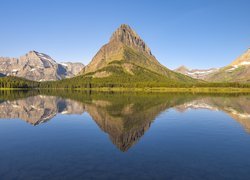 Odbicie rozświetlonych gór w jeziorze Swiftcurrent Lake