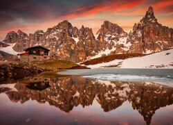 Odbicie schroniska Baita Segantini i szczytu Cimon della Pala w jeziorze