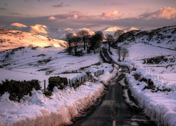 Odśnieżona górska droga ze śniegiem na poboczach