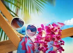 Okulary przeciwsłoneczne i kwiaty położone na leżaku