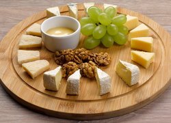 Orzechy i winogrona pośrodku kawałków sera