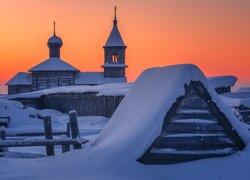 Ośnieżona cerkiew pod pomarańczowym niebem