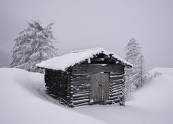 Ośnieżona chata w zaspach śnieżnych