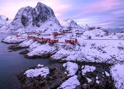 Ośnieżone czerwone domki na norweskich Lofotach