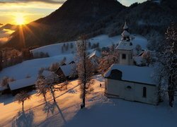 Ośnieżony kościół i domy w gminie Skofja Loka