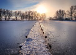 Ośnieżony pomost na zamarzniętym stawie