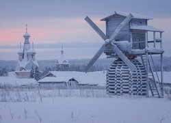 Ośnieżony wiatrak i cerkiew we wsi Kimzha