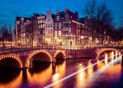 Oświetlone domy i most na rzece Amstel w Amsterdamie