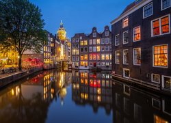 Oświetlone domy nad kanałem w Amsterdamie