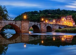 Oświetlone nocą domy i most nad rzeką Werra River