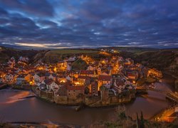 Oświetlone nocą Staithes nad rzeką Roxby Beck