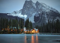 Oświetlony dom nad jeziorem Emerald Lake na tle gór