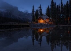 Oświetlony dom nad Jeziorem Emerald Lake nocą