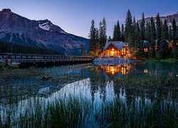 Oświetlony dom nocą nad jeziorem Emerald Lake