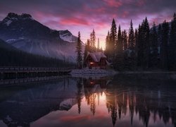 Oświetlony dom pod lasem nad jeziorem Emerald Lake