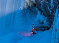Oświetlony dom pod oblodzoną skałą przy wodospadzie Niagara