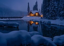 Oświetlony i ośnieżony dom nad jeziorem Emerald Lake