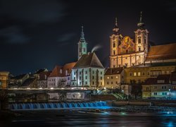 Oświetlony kościół i domy w Steyr nad rzeką w Austrii