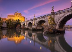 Oświetlony most i zamek Świętego Anioła nad rzeką Tyber w Rzymie