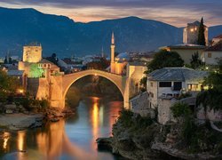 Oświetlony nocą most nad rzeką Neretwa w mieście Mostar