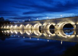 Oświetlony nocą most nad rzeką