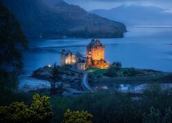 Oświetlony zamek Eilean Donan na wyspie w Szkocji