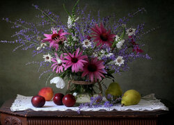 Owoce i kwiaty w wazonie na komodzie