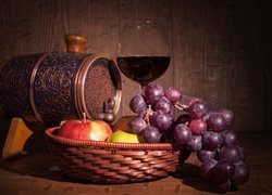 Owoce w koszyku obok kieliszka z winem