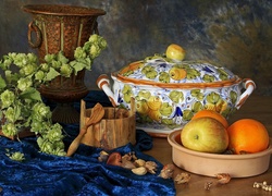 Owoce w miseczce obok wazy i chmielu w kompozycji na stole