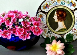 Ozdobny talerz obok pelargonii i róży