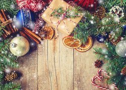 Ozdoby świąteczne i prezent pośród gałązek świerku