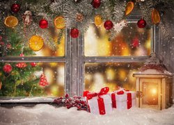Ozdoby świątecznie w oknie z lampionem i prezentami