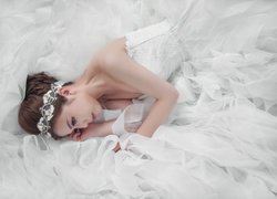 Panna młoda leżąca na sukni ślubnej