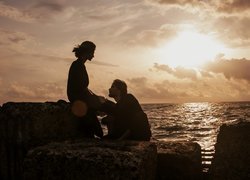 Para siedząca na skałach przy morzu