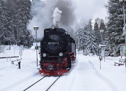 Parowóz na zasypanej śniegiem stacji kolejowej