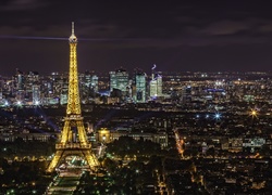 Paryż z wieżą Eiffla nocą oglądany z lotu ptaka