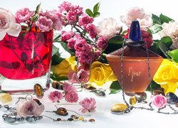 Perfumy i biżuteria obok róż