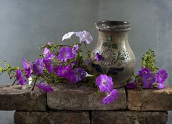 Petunie i wazon na kamiennym murku
