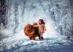 Pies rasy chow chow i dziewczynka w zimowej scenerii