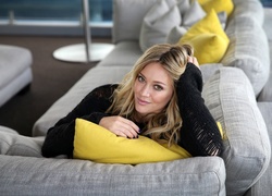Piosenkarka i aktorka Hilary Duff na kanapie z żółtymi poduszkami