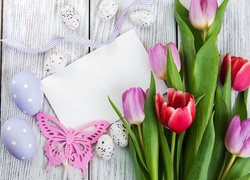 Pisanki i motylek obok tulipanów