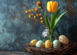 Pisanki w gniazdku i żółty tulipan w wazonie