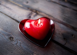 Płonąca czerwona świeczka w kształcie serca
