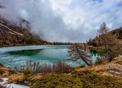 Pochmurne niebo i mgła nad Alpami i jeziorem Aviolo Lake