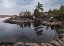 Pochmurne niebo nad skałami i jeziorem Ładoga