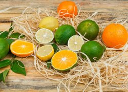Pomarańcze cytryny i limonki ułożone na deskach