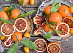 Pomarańcze i owoce kumkwatu na talerzach