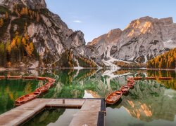 Pomost i szereg łodzi zacumowanych na jeziorze Pragser Wildsee